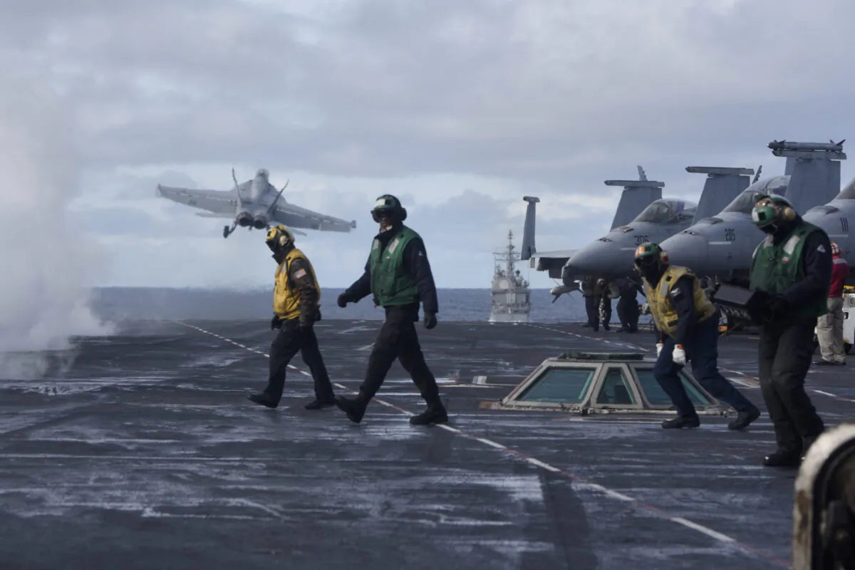 Sailors stand on the flight deck after launching an F/A-18F Super Hornet from the the Nimitz-class aircraft carrier USS Harry S. Truman (CVN 75) in the North Atlantic on Sept. 18, 2018. (2nd Class Anthony Flynn/DoD)