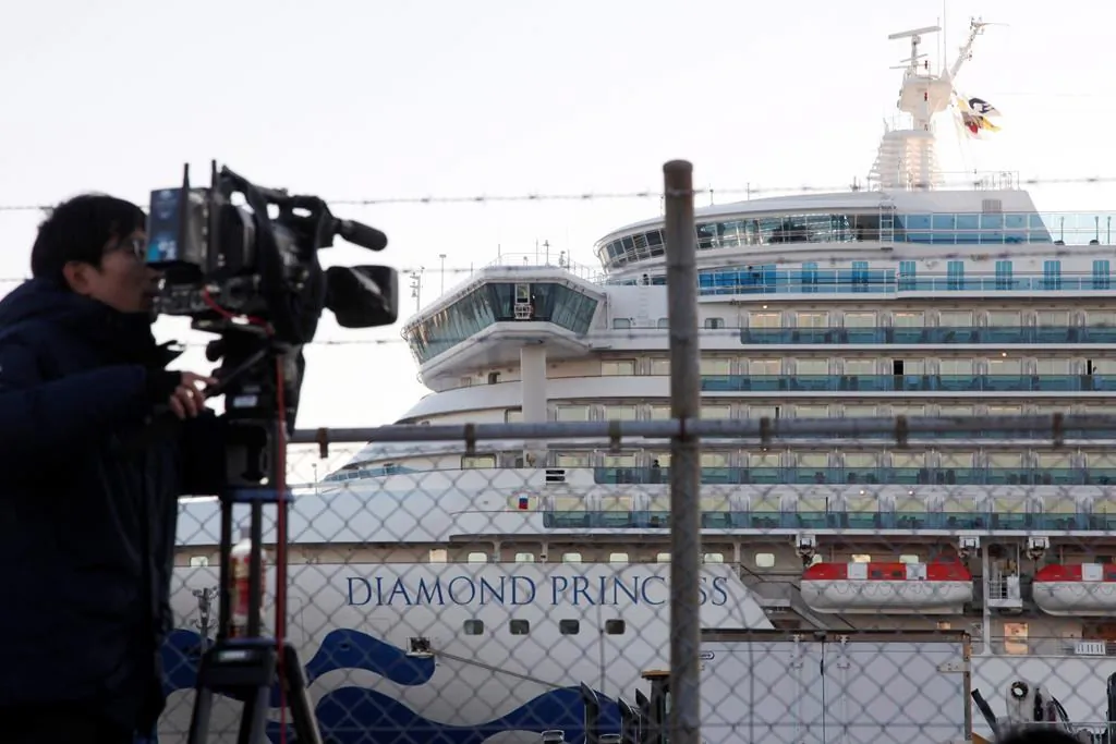 A TV cameraman films the quarantined ship Diamond Princess, anchored at Yokohama port in Yokohama, near Tokyo, on Feb. 18, 2020. (AP Photo/Koji Sasahara)