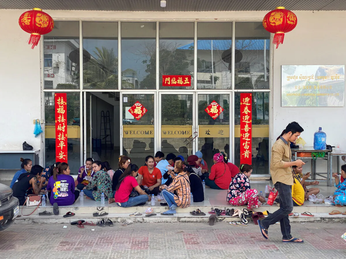 Cambodian workers eat lunch outside a Chinese-operated factory in the Chinese-managed Special Economic Zone (SEZ) in the city of Sihanoukville, Cambodia on Feb. 15, 2020. (Matthew Tostevin/Reuters)