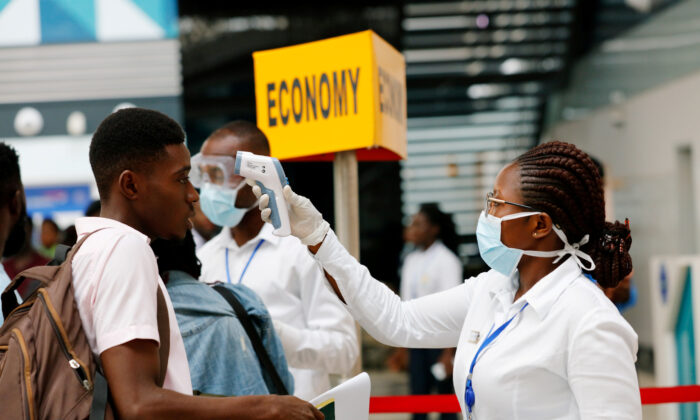 A health worker checks the temperature of a man as part of the coronavirus screening procedure at the Kotoka International Airport in Accra, Ghana on Jan. 30, 2020. (Francis Kokoroko/Reuters)