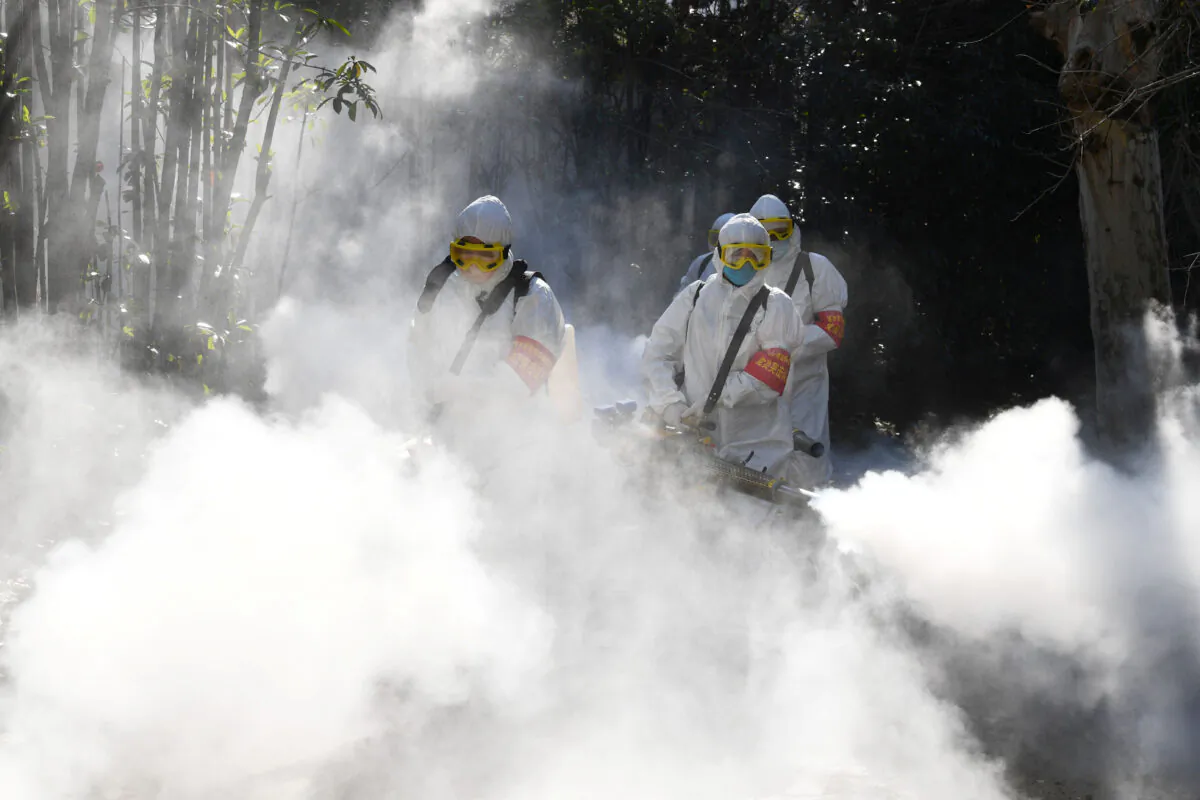 Sanitation workers disinfect a residential compound, as China is hit by an outbreak of the novel coronavirus in Bozhou in Anhui Province, China on Feb. 18, 2020. (China Daily via Reuters)