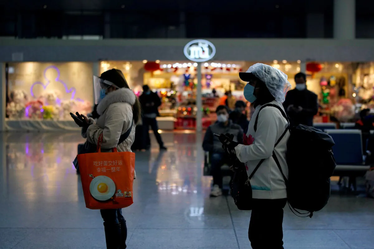 Travelers with face masks and shields are seen at the Shanghai Hongqiao Railway Station on the last day of the Spring Festival travel rush, as the country is hit by an outbreak of the novel coronavirus, in Shanghai, China on Feb. 18, 2020. (Aly Song/Reuters)