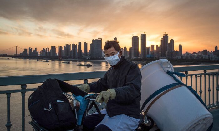A man wears a protective face mask on a scooter in Wuhan, Hubei province, China, on Feb. 17, 2020. (STR/AFP via Getty Images)