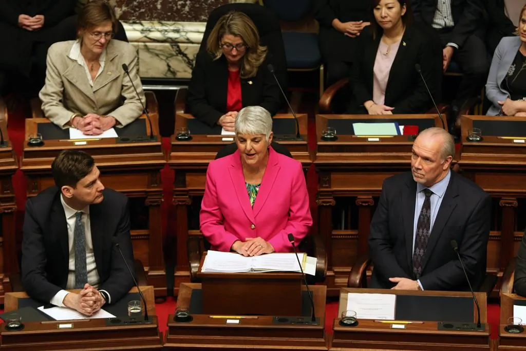 Attorney General David Eby and Premier John Horgan look on as Minister of Finance Carole James delivers the budget speech from the legislative assembly at B.C. Legislature in Victoria, B.C., on Feb. 18, 2020. (Chad Hipolito/The Canadian Press)