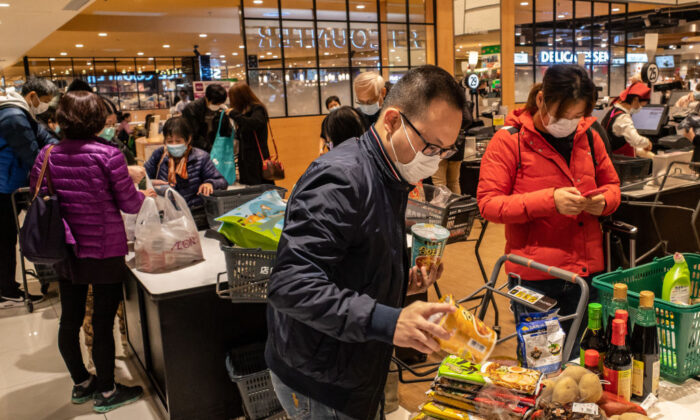Shoppers wearing face masks bag up their purchases at a grocery store in Hong Kong on Feb. 9, 2020. (Anthony Kwan/Getty Images)