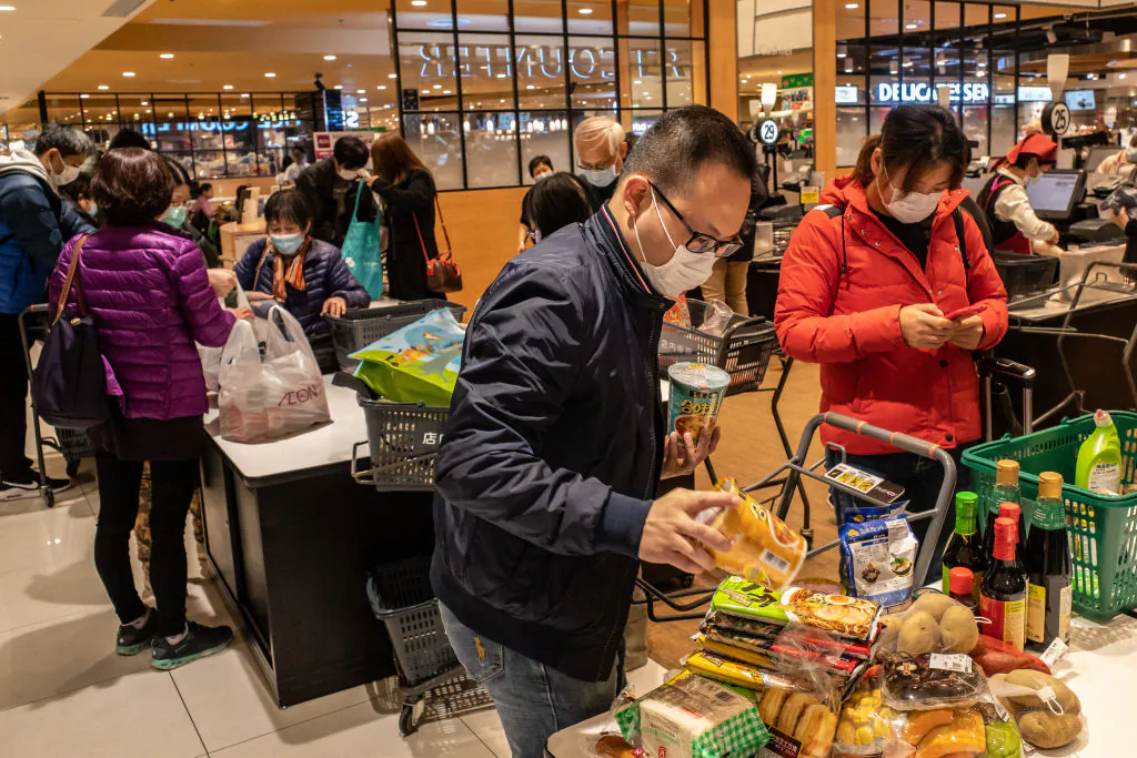 Shoppers wearing face masks bag up their purchases at a grocery store in Hong Kong on Feb. 9, 2020. (Anthony Kwan/Getty Images)