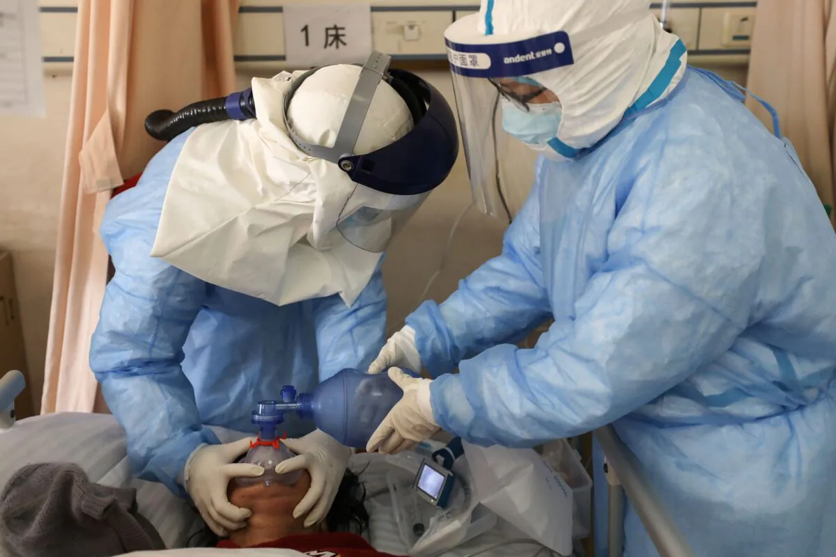Medical staff members are treating a patient infected by the COVID-19 coronavirus at the Wuhan Red Cross Hospital in Wuhan, China on Feb. 16, 2020. (TR/AFP via Getty Images)