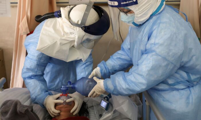 Medical staff members are treating a patient infected by the COVID-19 coronavirus at the Wuhan Red Cross Hospital in Wuhan, China on Feb. 16, 2020. (TR/AFP via Getty Images)