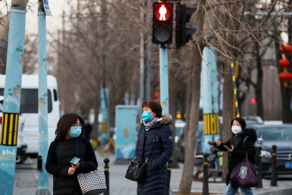 Chinese women wear a mask as they wait to cross a street in Beijing on Feb. 18, 2020. (Lintao Zhang/Getty Images)