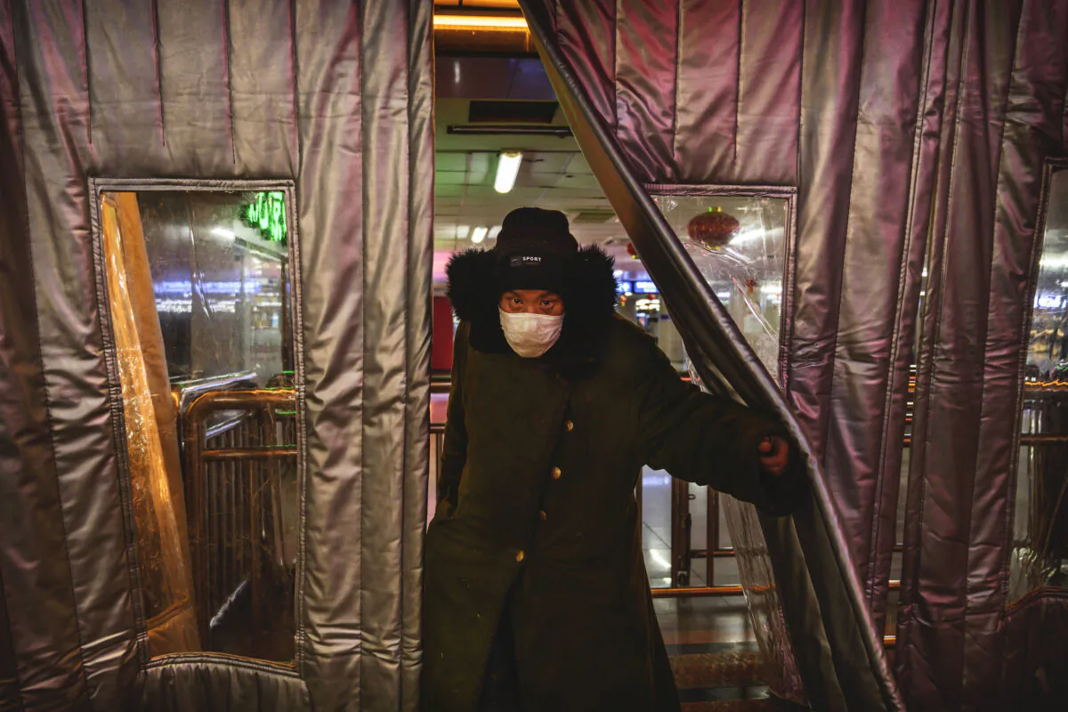 A Chinese man wears a protective mask as he walks outside of a subway station in Beijing on Feb. 16, 2020. (Kevin Frayer/Getty Images)