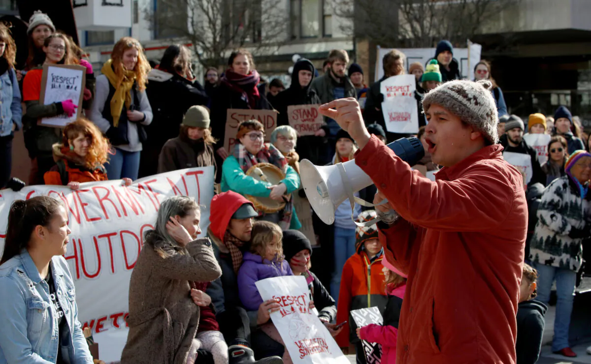 Protestor Saul Brown speaks to other demonstrators outside the Business Development Bank of Canada at 1515 Douglas Street as part of a protest against the Coastal GasLink pipeline, in Victoria on Feb. 14, 2020.  (Kevin Light/Reuters)