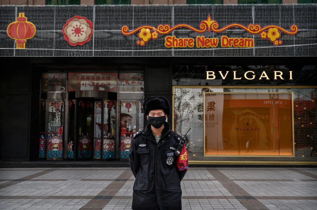A Chinese security guard wears a protective mask as he stands on a commercial street in Beijing, China, on Feb. 18, 2020. (Kevin Frayer/Getty Images)