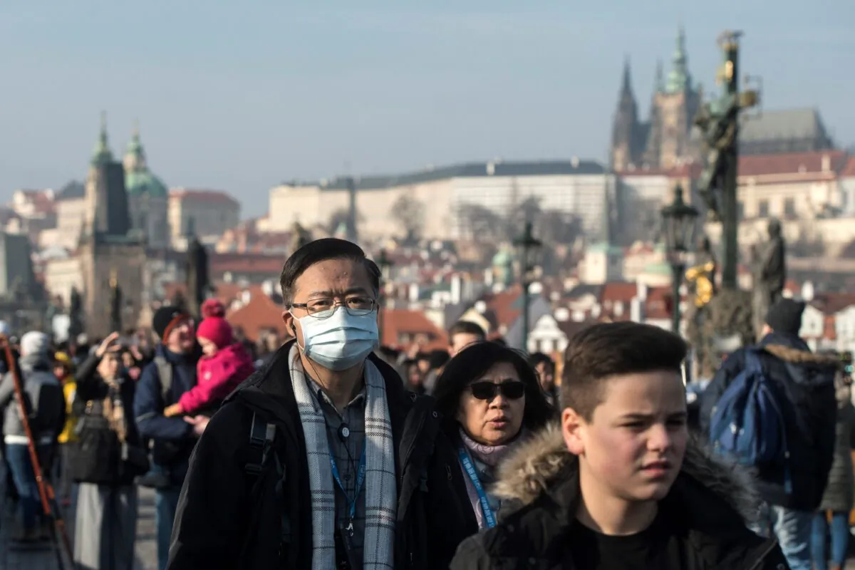 People wear mask as they walk on the Charles bridge in Prague, Czech Republic on Jan. 27, 2020. (Michal Cizek/AFP via Getty Images)