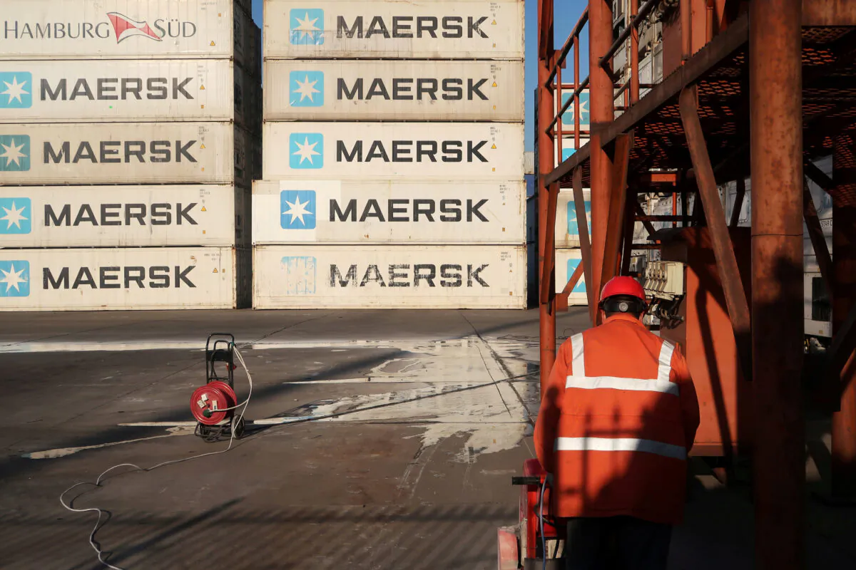 A worker is seen next to Maersk shipping containers at a logistics center near Tianjin port, in Tianjin, China on Dec. 12, 2019. (Yilei Sun/Reuters)