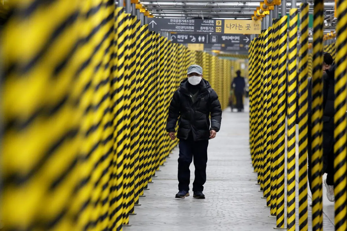 A man wearing a mask as a preventive measure against the coronavirus walks at a subway station in Seoul, South Korea on Feb. 20, 2020. (Heo Ran/Reuters)