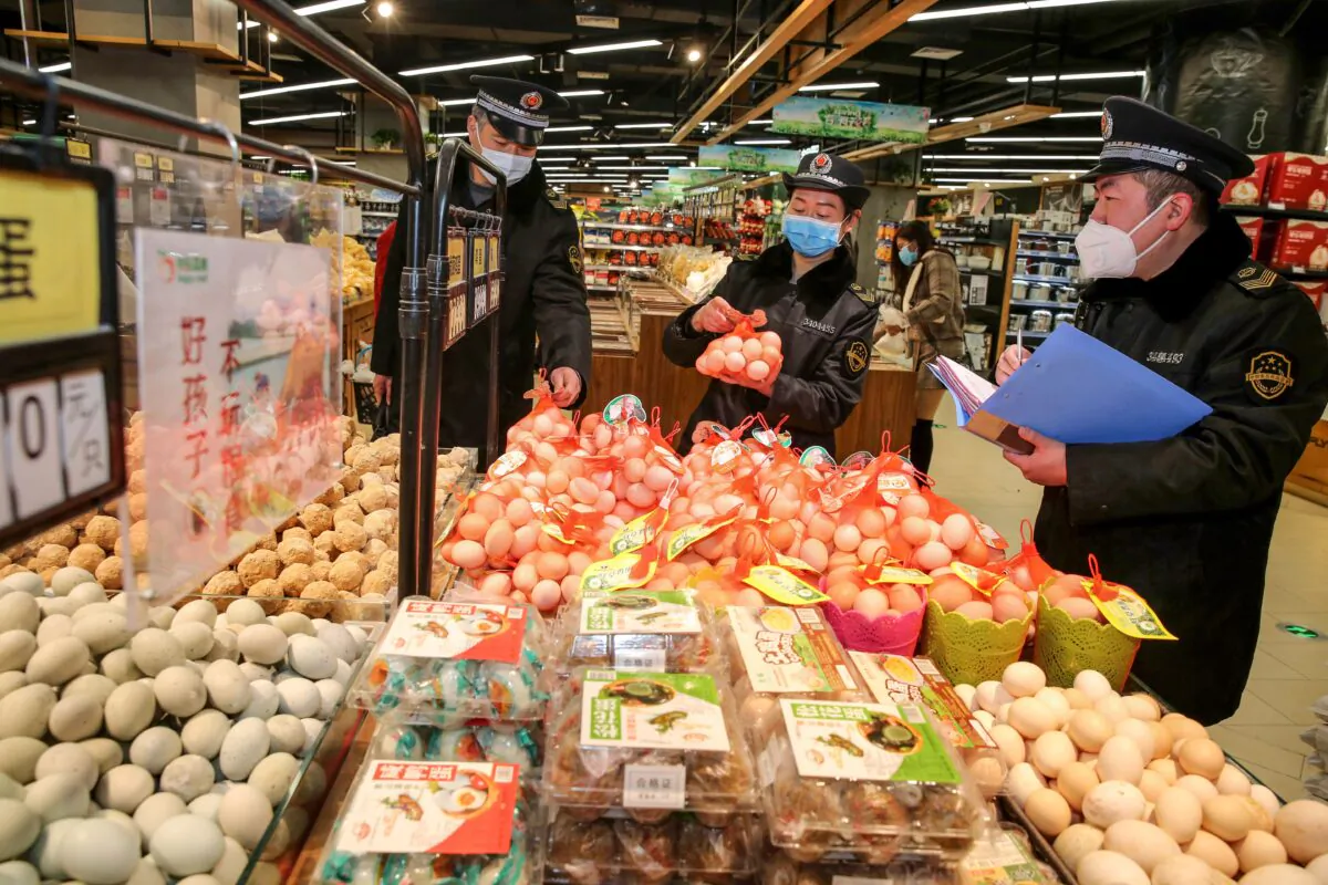 This photo taken on Feb. 20, 2020 shows market supervision administer checking eggs in a supermarket as they monitor the price of commodities during the COVID-19 coronavirus outbreak in Huaibei in China's eastern Anhui province. (STR/AFP via Getty Images)