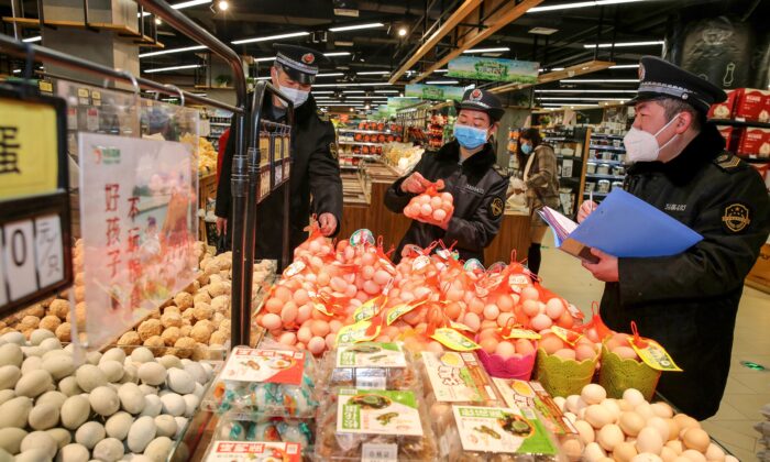 This photo taken on Feb. 20, 2020 shows market supervision administer checking eggs in a supermarket as they monitor the price of commodities during the COVID-19 coronavirus outbreak in Huaibei in China's eastern Anhui province. (STR/AFP via Getty Images)