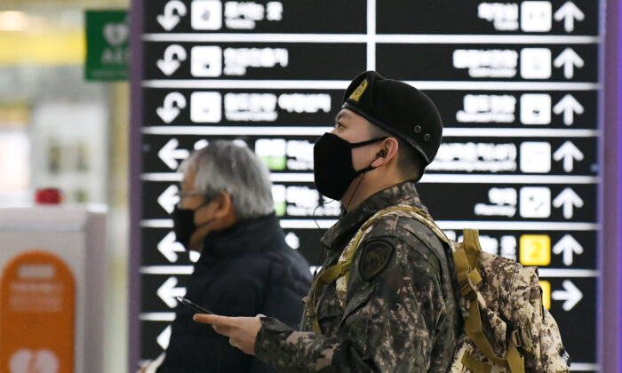 A South Korean soldier (R) wearing a face mask looks at train departure timetable at a railway station in the southeastern city of Daegu, South Korea, on Feb. 21, 2020. (JUNG YEON-JE/AFP via Getty Images)