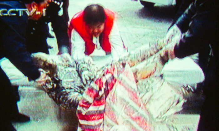 Chinese television footage shows a badly burned individual from the alleged self-immolation incident at Tiananmen Square on Jan. 23, 2001. The incident was staged by the CCP to slander the peaceful practice of Falun Gong. 
 (Newsmakers/Getty Images)