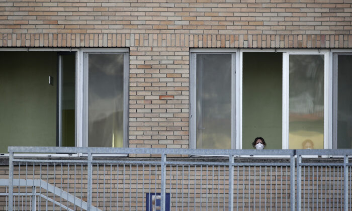 A nurse wearing a sanitary mask watches from a window of the hospital of Codogno, near Lodi in Northern Italy on Feb. 21, 2020. (Luca Bruno/AP Photo)