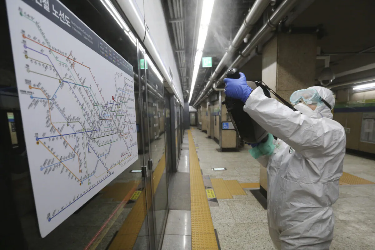 A worker wearing protective gears sprays disinfectant as a precaution against the coronavirus at a subway station in Seoul, South Korea, on Feb. 21, 2020. (Ahn Young-joon/AP Photo)
