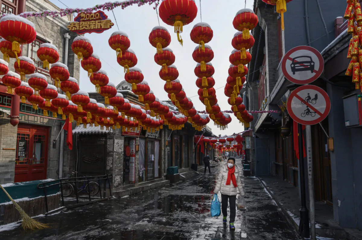 A Chinese woman wears a protective mask as she walks in a nearly empty and shuttered commercial street in Beijing on Feb. 7, 2020. (Kevin Frayer/Getty Images)