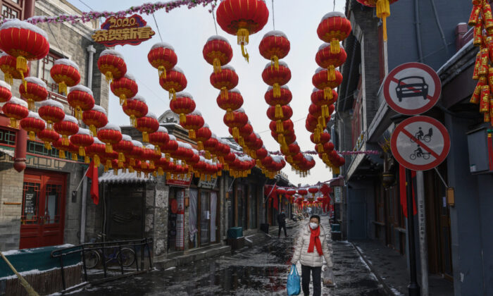 A Chinese woman wears a protective mask as she walks in a nearly empty and shuttered commercial street in Beijing on Feb. 7, 2020. (Kevin Frayer/Getty Images)