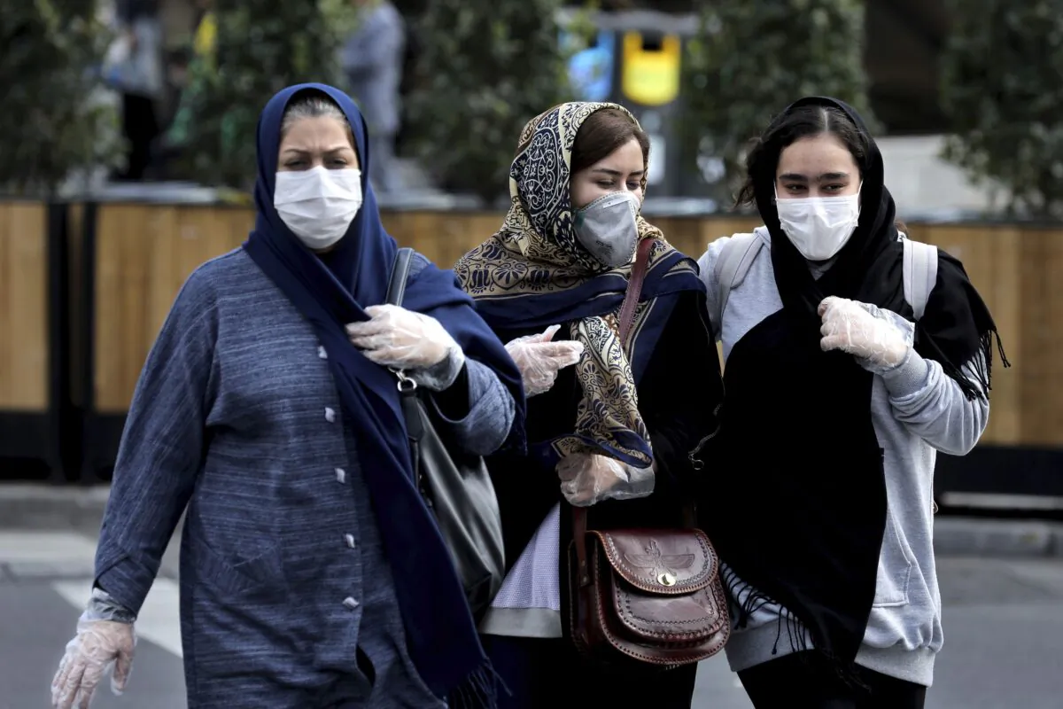 Women wear masks and gloves to help guard against the coronavirus in downtown Tehran, Iran on Feb. 23, 2020. (Ebrahim Noroozi/AP Photo)