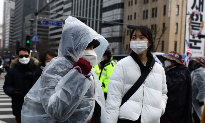 People wear masks to prevent the novel coronavirus walk along the street in Seoul, South Korea, on Feb. 22, 2020. (Chung Sung-Jun/Getty Images)