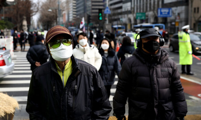 People wear masks to prevent the novel coronavirus walks along the street in Seoul, South Korea, on Feb. 22, 2020. (Chung Sung-Jun/Getty Images)