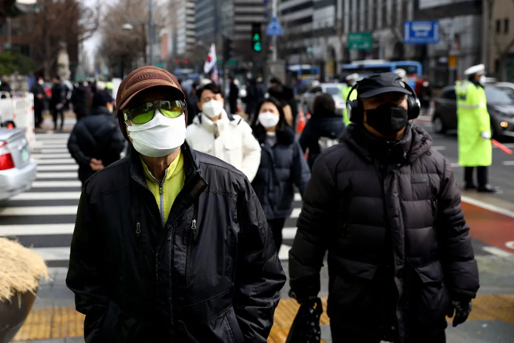 People wear masks to prevent the novel coronavirus walks along the street in Seoul, South Korea, on Feb. 22, 2020. (Chung Sung-Jun/Getty Images)