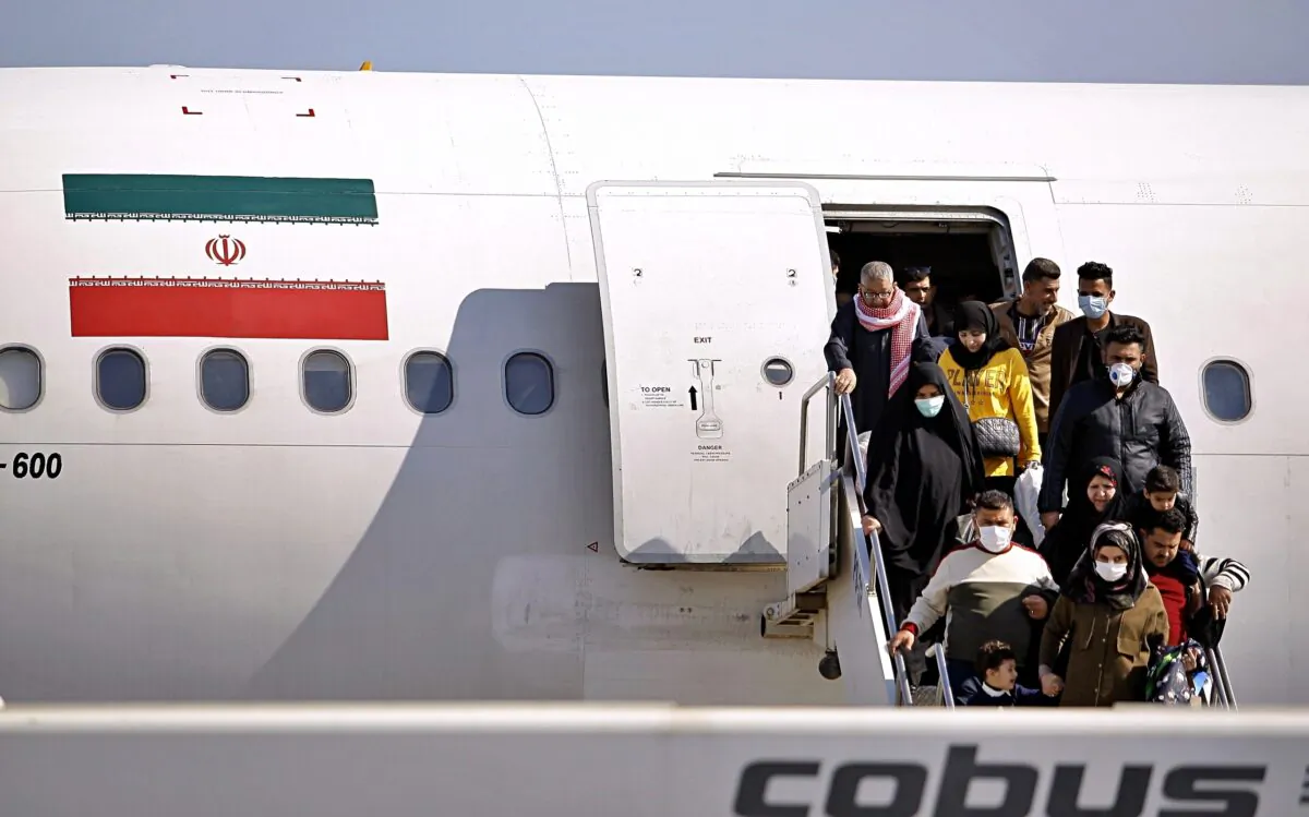 Passengers disembarking from an Iranian plane in the airport in Najaf, Iraq, on Feb. 21, 2020. (Anmar Khalil/AP Photo)