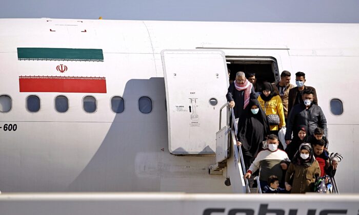 Passengers disembarking from an Iranian plane in the airport in Najaf, Iraq, on Feb. 21, 2020. (Anmar Khalil/AP Photo)