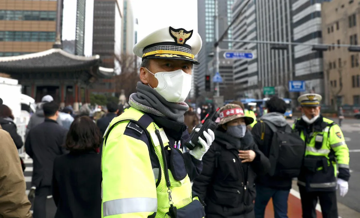 A South Korean policeman wearing a mask to prevent the coronavirus (COVID-19) walks along the street in Seoul, South Korea, on Feb. 22, 2020. (Chung Sung-Jun/Getty Images)
