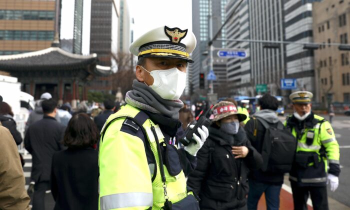 A South Korean policeman wearing a mask to prevent the coronavirus (COVID-19) walks along the street in Seoul, South Korea, on Feb. 22, 2020. (Chung Sung-Jun/Getty Images)