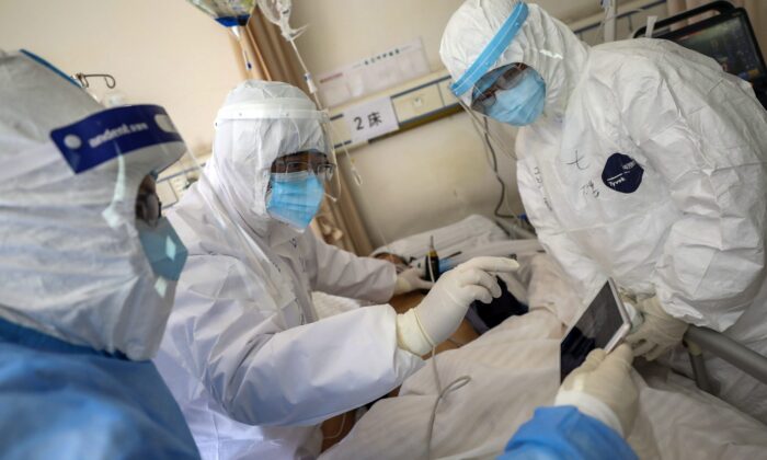Medical personnel scan a new coronavirus patient at a hospital in Wuhan in central China's Hubei province on Feb. 16, 2020. (Chinatopix via AP)