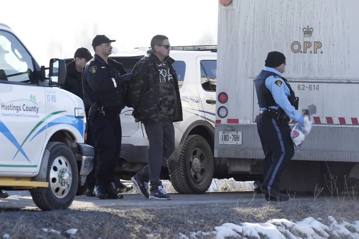 Ontario Provincial Police officers arrest a man at a rail blockade in Tyendinaga Mohawk Territory, near Belleville, Ont., on Feb. 24, 2020, who was part of a  protest in solidarity with Wet'suwet'en Nation hereditary chiefs attempting to halt construction of a natural gas pipeline on their traditional territories. (The Canadian Press/Adrian Wyld)
