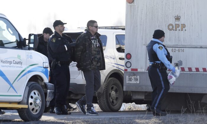 Ontario Provincial Police officers arrest a man at a rail blockade in Tyendinaga Mohawk Territory, near Belleville, Ont., on Feb. 24, 2020, who was part of a  protest in solidarity with Wet'suwet'en Nation hereditary chiefs attempting to halt construction of a natural gas pipeline on their traditional territories. (The Canadian Press/Adrian Wyld)
