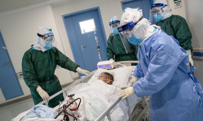 Medical staff transfer a patient infected by the Novel Coronavirus at a hospital in Wuhan in China's central Hubei province on Feb. 22, 2020. (STR/AFP via Getty Images)