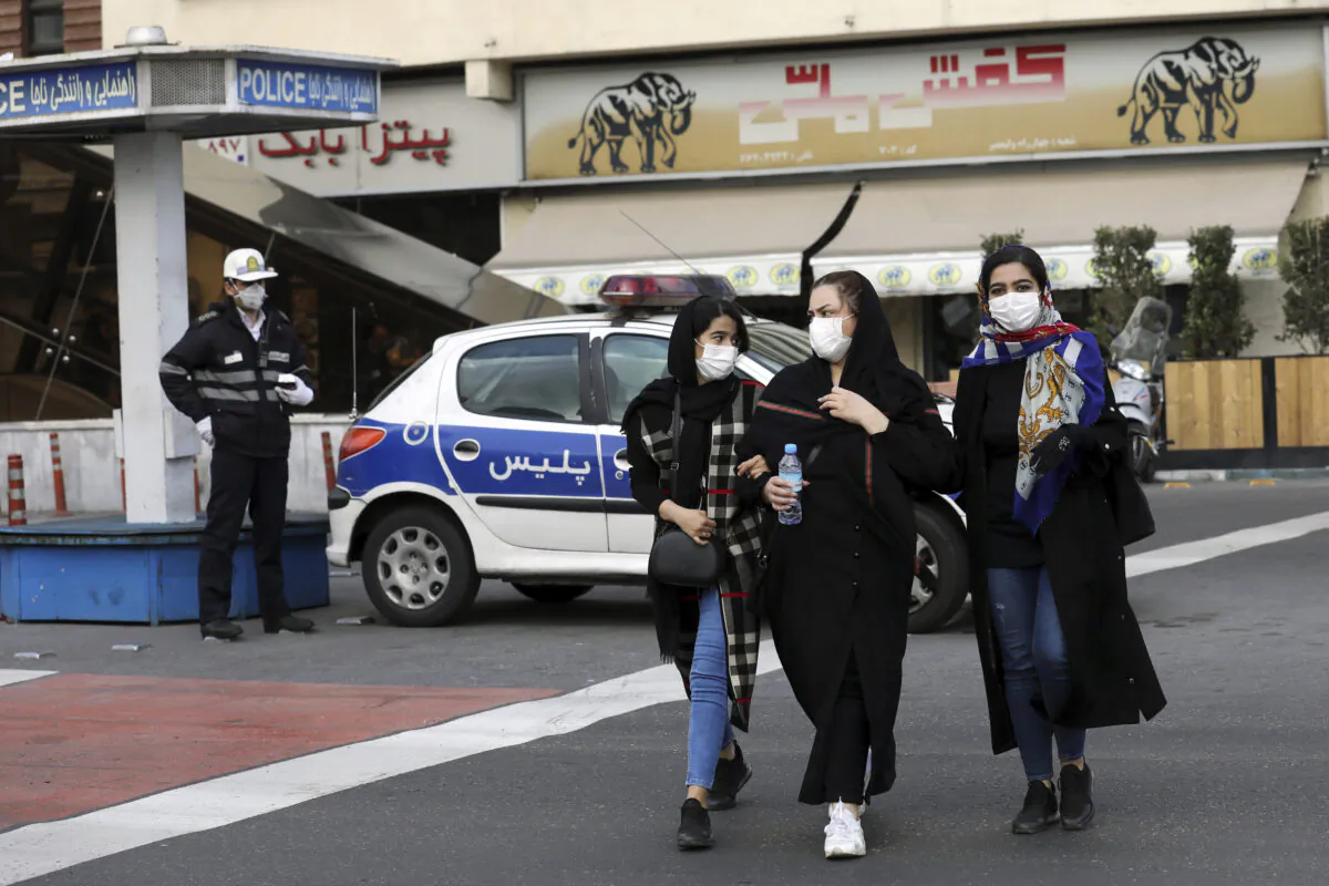 A policeman and pedestrians wear masks to help guard against the coronavirus in downtown Tehran, Iran, on Feb. 23, 2020. (Ebrahim Noroozi/AP Photo)