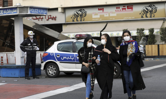 A policeman and pedestrians wear masks to help guard against the coronavirus, in downtown Tehran, Iran, on Feb. 23, 2020. (Ebrahim Noroozi/AP Photo)