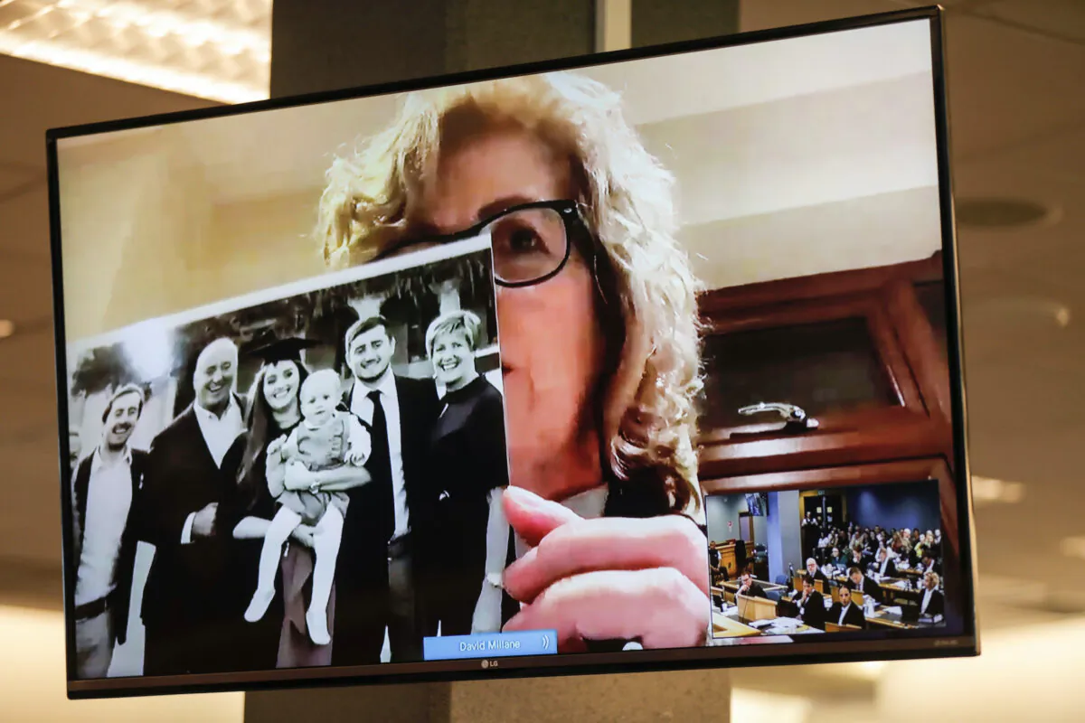 Gillian Millane, mother of murdered British backpacker Grace, holds up a photo during her victim impact statement via video link from England, at the sentencing of the man found guilty of her murder at the Auckland High Court in Auckland, New Zealand on Friday, Feb. 21, 2020. (Dean Purcel/New Zealand Herald via AP)