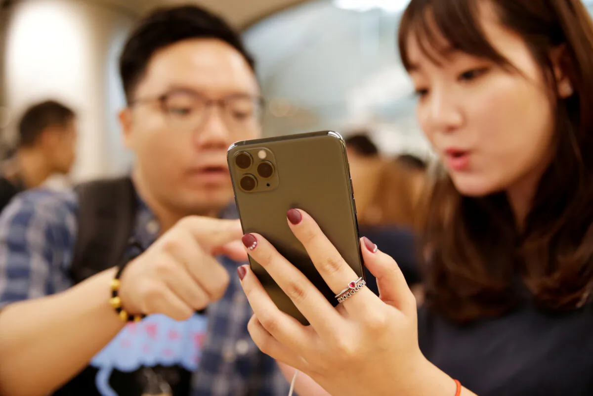 A customer touches an Apple's new iPhone 11 Pro Max after it went on sale at the Apple Store in Beijing, China, on Sept. 20, 2019. (Jason Lee/Reuters)