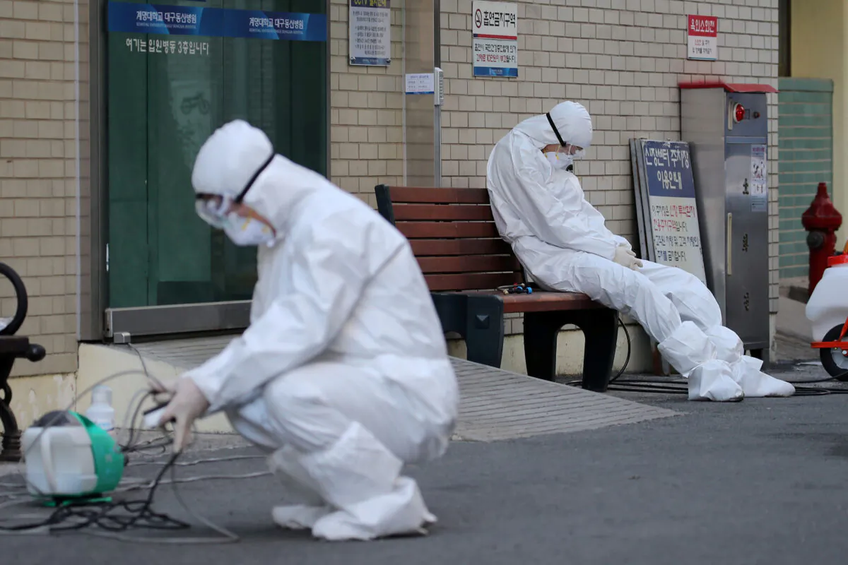 A medical worker takes a rest outside a hospital in Daegu, South Korea, on Feb. 23, 2020. (Yonhap via Reuters)