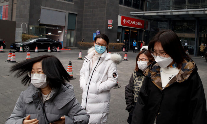 People wear face masks as they leave an office building in the Central Business District in Beijing as the country is hit by an outbreak of the novel coronavirus, China on Feb. 24, 2020. (Thomas Peter/Reuters)