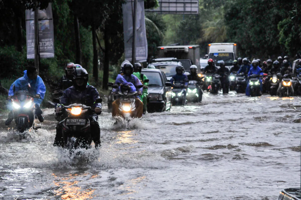People ride motorcycles along a flooded street in Bekasi, near Jakarta, Indonesia, on Feb. 25, 2020. (Antara Foto/Fahkri Hermansyah/ via Reuters)