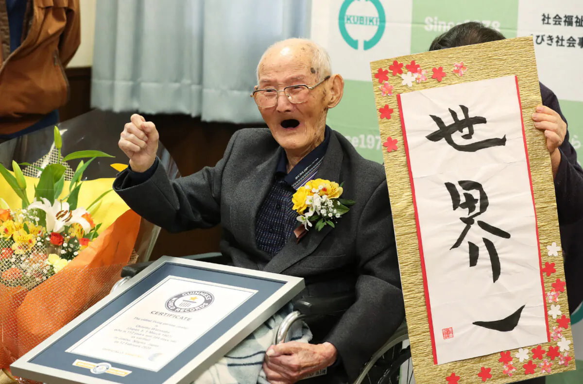 112-year-old Japanese man Chitetsu Watanabe poses next to calligraphy reading in Japanese 'World Number One' after he was awarded as the world's oldest living male in Joetsu, Niigata prefecture on Feb. 12, 2020. (Photo by Japan Pool/JIJI PRESS/AFP via Getty Images)
