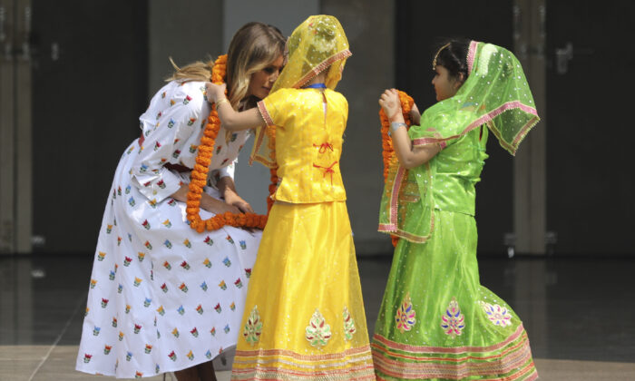 U.S. First Lady Melania Trump is garlanded by two children at Sarvodaya Co-Educational Senior Secondary School in New Delhi, India, on Feb. 25, 2020. (Altaf Qadri/AP Photo)