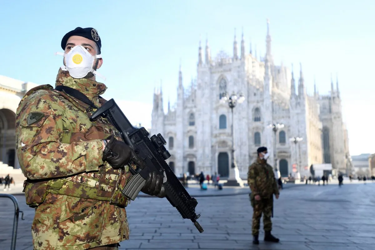 Military officers wearing face masks stand outside Duomo cathedral, closed by authorities due to a coronavirus outbreak, in Milan, Italy, on Feb. 24, 2020. (Flavio Lo Scalzo/Reuters)