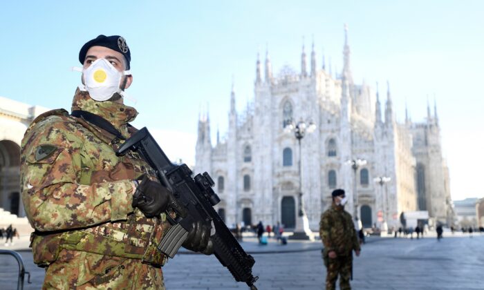 Military officers wearing face masks stand outside Duomo cathedral, closed by authorities due to a coronavirus outbreak, in Milan, Italy, on Feb. 24, 2020. (Flavio Lo Scalzo/Reuters)